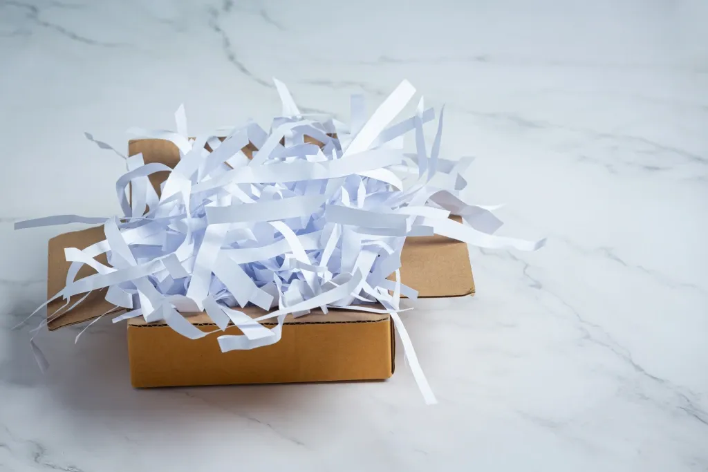 caisse de carton remplie d'un contrat d'assurance résilié et déchiré